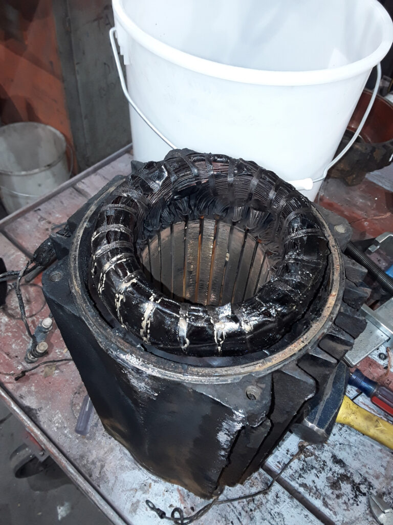 Usuwanie starego uzwojenia z rdzenia statora palnikiem gazowym i szczypcami metalowymi