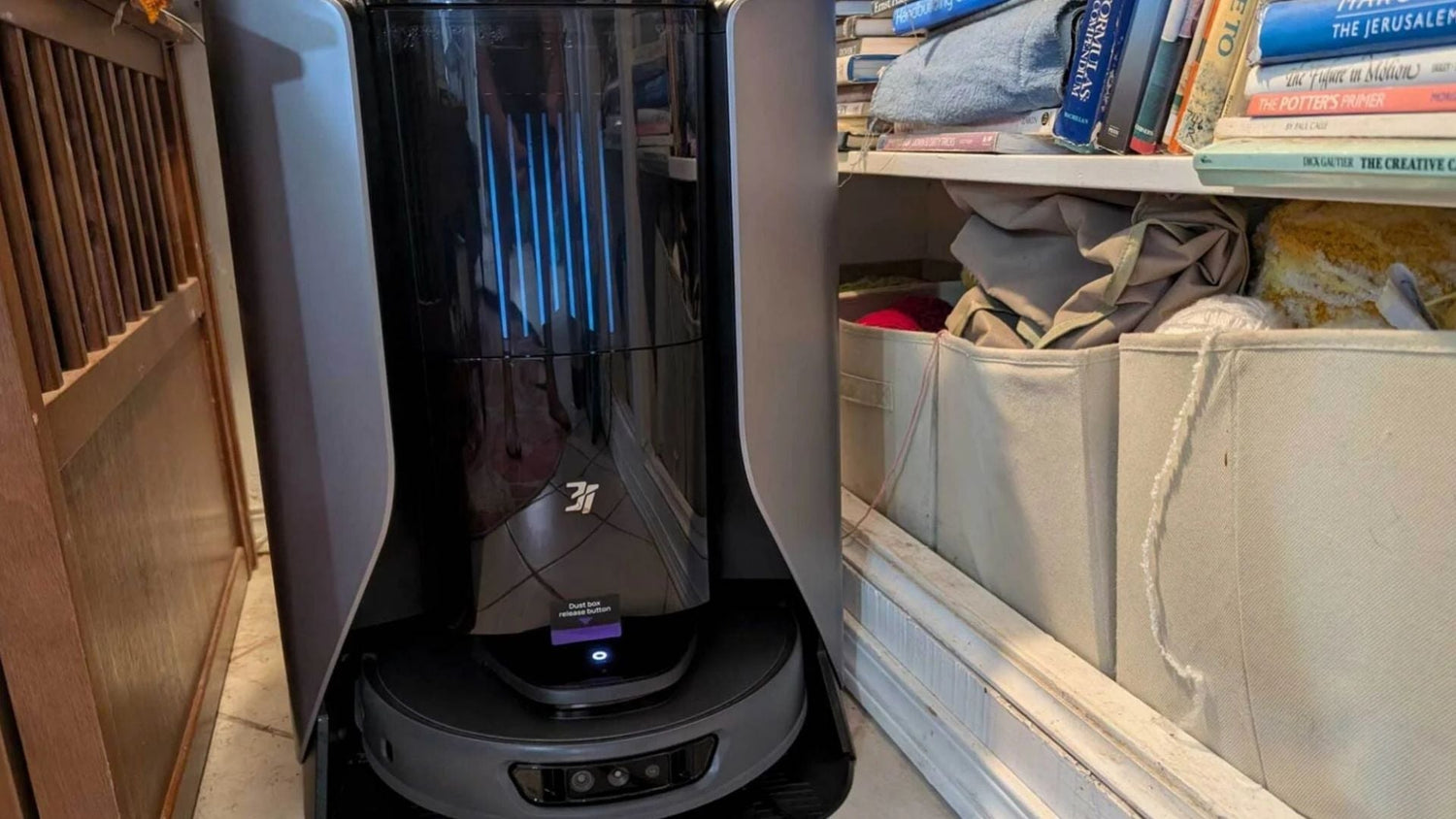 Robot sprzątający wczołguje się pod sofę zbierając kurz i sierść kota