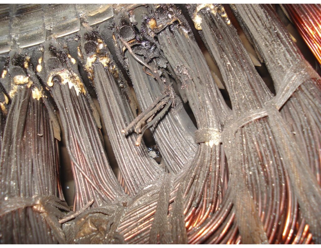 Technik w warsztacie przewija uzwojenie statora silnika elektrycznego na stole roboczym