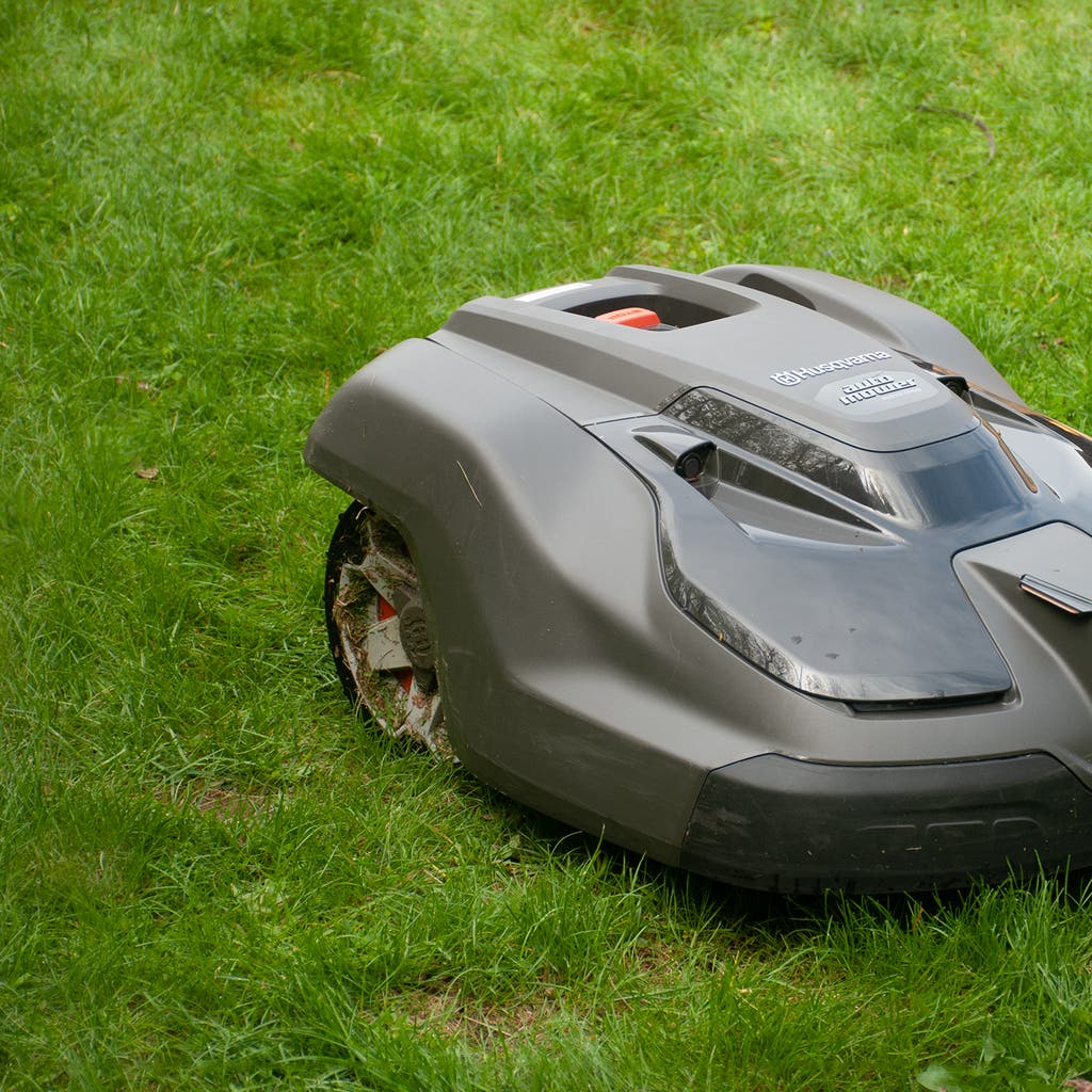 Montaż granicy wirtualnej dla robota koszącego Instalacja przewodu granicznego wokół trawnika z robotem testującym nową granicę